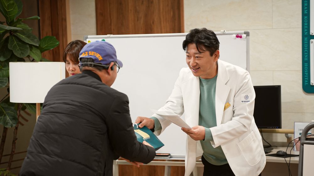 메디람한방병원 김지호 대표원장이 환우 교육을 마친 환자에게 자료를 전달하는 모습
