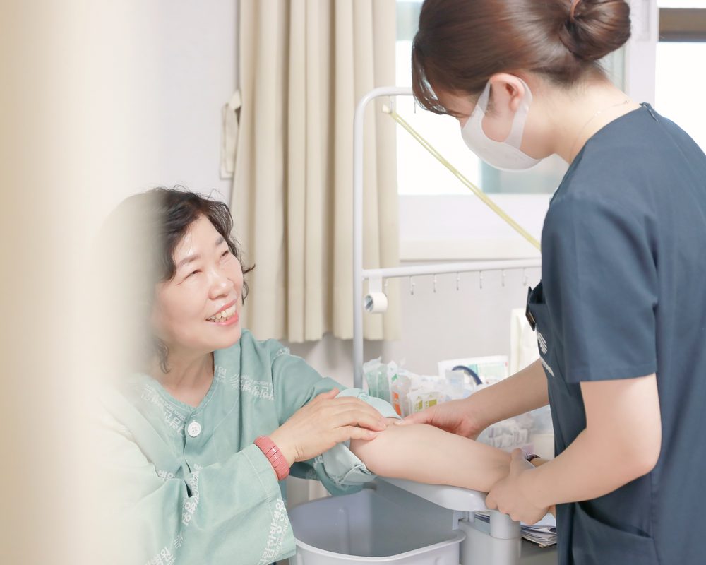 메디람한방병원 간호사가 입원 환자의 팔을 살피며 피부 상태를 확인하는 모습
