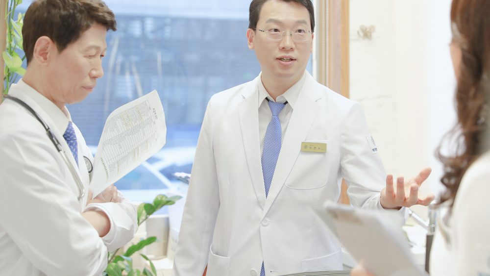원장들이 치료 일정표를 들고 항암 주기 중인 입원 환자의 다음 관리 계획을 의논하는 모습