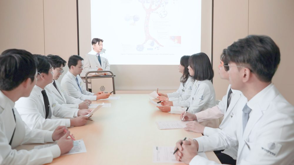 회의실에서 의료진이 화면 속 자료를 보며 함께 복용 중인 약 목록을 검토하는 협진 회의 모습